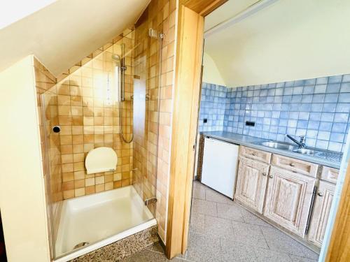 Un baño con bañera, lavabo y ducha. en Les Charmes, en Chevron