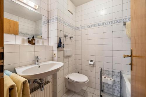 a white bathroom with a sink and a toilet at Fewo Brünnstein - Zimmer 6 in Oberaudorf