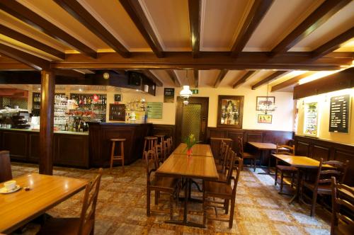 a restaurant with wooden tables and chairs and a bar at Hôtel de la Croix-Blanche in Cressier