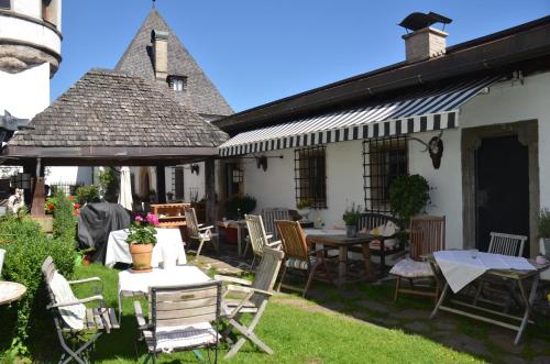 a patio of a house with tables and chairs at Schloss Münichau in Reith bei Kitzbühel