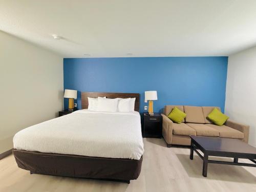 a bedroom with a large bed and a couch at Hallmark Inn & Suites Newly Renovated Rooms San Antonio Northeast in San Antonio