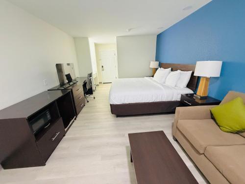 a hotel room with a bed and a couch at Hallmark Inn & Suites Newly Renovated Rooms San Antonio Northeast in San Antonio
