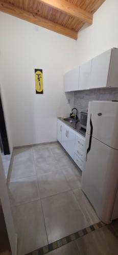 a kitchen with a white refrigerator and white cabinets at Las Blanco in Sierra Grande