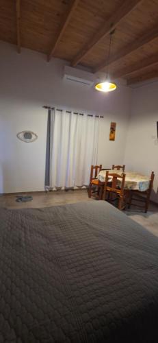 a bedroom with a bed and a table and chairs at Las Blanco in Sierra Grande