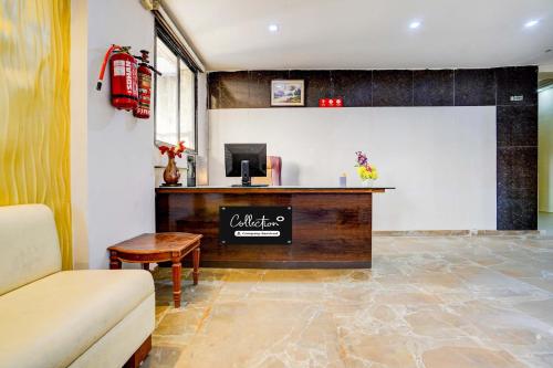 Un vestíbulo con un mostrador de recepción y un sofá. en Collection O Infocity Metro Station Gandhinagar Formerly Hotel LLP, en Gandhinagar