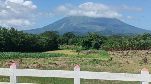 une montagne au loin avec une clôture blanche dans l'établissement Casa Del Árbol - Ometepe, à Santa Ana