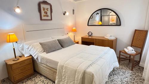 a bedroom with a large white bed and a mirror at Vistamar Porto Cristo in Porto Cristo