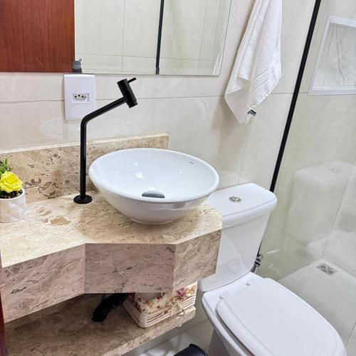a bathroom with a sink and a toilet at Melges Apart Hotel in Pontes e Lacerda