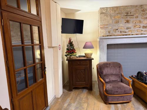 a living room with a chair and a christmas tree at Maison 4ch, 5 lits, terrasse, Terrasson Dordogne in Terrasson-Lavilledieu