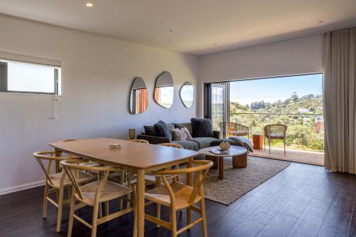 a living room with a table and a couch at Hidden Valley Waiheke in Palm Beach