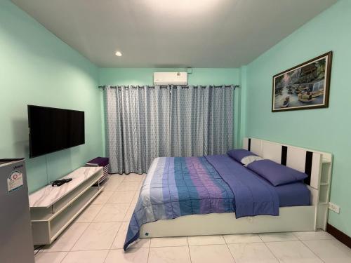 a bedroom with a bed and a flat screen tv at Best Rent a Room in Nai Yang Beach