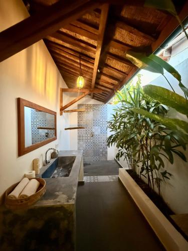 a bathroom with a sink and a potted plant at Joglo Villas Uluwatu - Tropical Oasis in Uluwatu