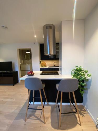 una cocina con 2 sillas y una isla de cocina en Art Nouveau in the middle of downtown Ålesund, en Ålesund