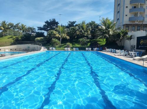 a swimming pool with blue water in a resort at Flat de 1 Qto Golden Dolphin Roberto Imóveis in Caldas Novas