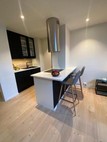 cocina con encimera blanca, mesa y sillas en Art Nouveau in the middle of downtown Ålesund, en Ålesund