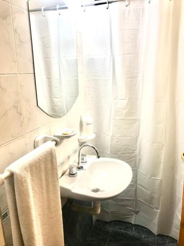 a white bathroom with a sink and a mirror at Duplex SM con ESTACIONAMIENTO in San Juan