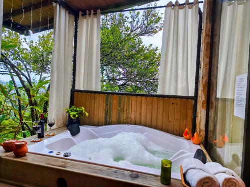 a bath tub in a room with a window at CABAÑAS MONTEVERDE - Guarne ANT in Guarne
