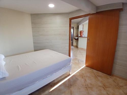 弗洛里亚诺波利斯Casinha de Hobbit的一间卧室配有一张床,一扇门通往厨房