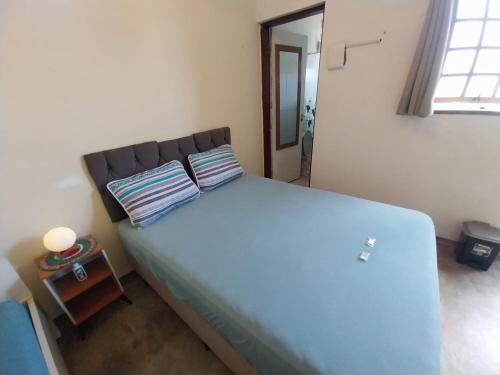 Kitnet - quarto - privativo في إتوبيفا: غرفة نوم بسرير كبير عليها وسادتين