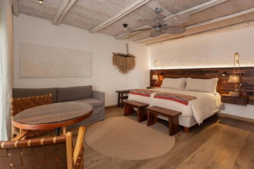 un dormitorio con una cama y un sofá en Casa Solcor Boutique Bed & Breakfast, en San Pedro de Atacama