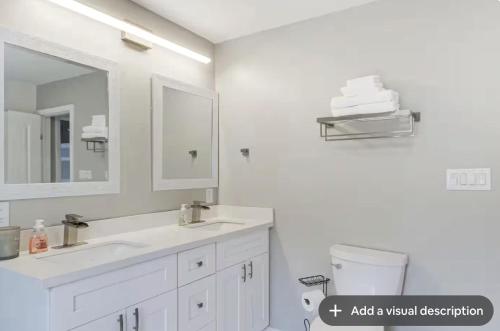 ein Badezimmer mit Waschbecken, Spiegel und Toilette in der Unterkunft Luxury Waterfront property in Bay Saint Louis