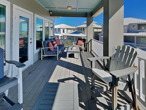 una veranda con panche e sedie su una casa di Salty Kisses a Padre Island