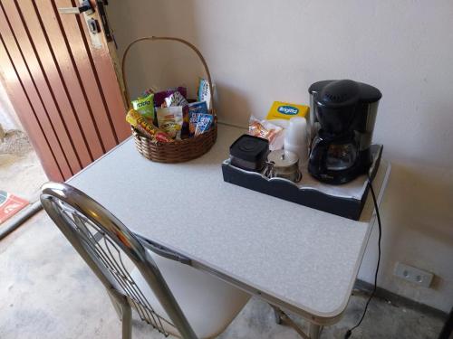 Kitnet - quarto - privativo في إتوبيفا: طاولة عليها صانع قهوة وسلة