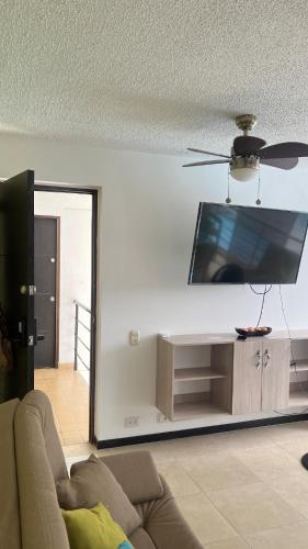 Una sala de estar con un sofá y un televisor de pantalla plana. en Apartamento en Santa Fe, en Santa Fe de Antioquia