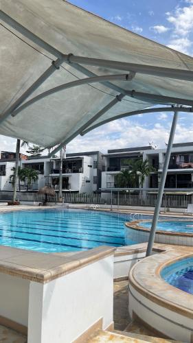 una gran piscina con una gran sombrilla blanca en Apartamento en Santa Fe, en Santa Fe de Antioquia
