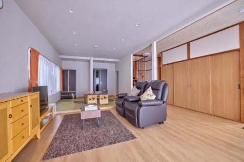 a living room with a couch and a television at APROStay富士河口湖小立17 in Fujikawaguchiko