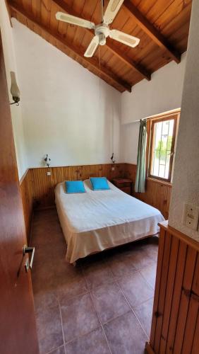 ein Schlafzimmer mit einem Bett und einem Deckenventilator in der Unterkunft Los Dos Pinos in Villa Gesell