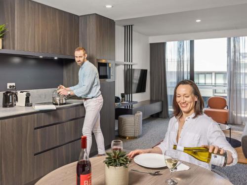 a man standing in a kitchen with a woman at The Sebel Canberra Campbell in Canberra
