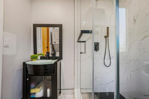 een badkamer met douche, wastafel en spiegel bij Rustic Lakefront Cottage with Fire Pit and Scenic Views in Brechin