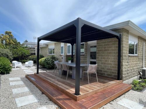 a gazebo with a table on a wooden deck at Nelson Bridge House in Nelson