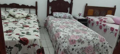 two beds sitting next to each other in a room at Suíte Tripla Bougainville 2 in Areia