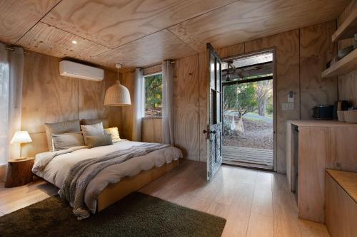 a bedroom with a bed and a sliding glass door at Gabion Hill in Glenlyon