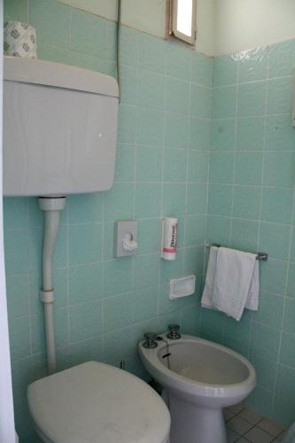 a blue bathroom with a toilet and a sink at Alba Hotel in Marina di Ravenna