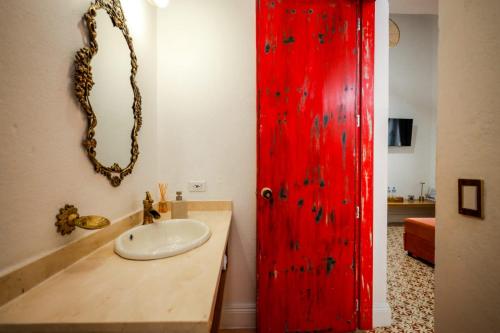 a bathroom with a red door and a sink at La Casa de Isa in Cali