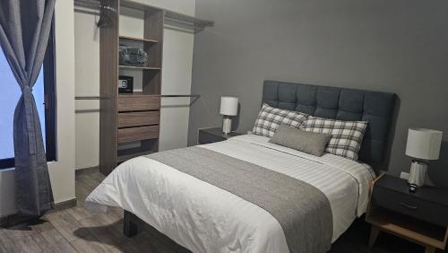a bedroom with a large bed with a blue headboard at Suite Perote in Perote