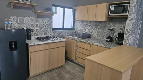 a kitchen with a black refrigerator and wooden cabinets at Suite Perote in Perote