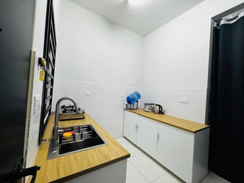 una cocina con fregadero y estufa horno superior en QQ UniStay, en Pagoh