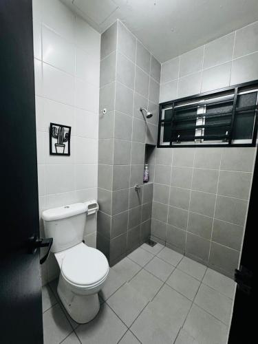 a bathroom with a white toilet and a window at QQ UniStay in Pagoh