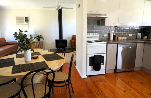 Denman Stay - Worker Friendly & Great Value في Denman: مطبخ وغرفة معيشة مع طاولة وكراسي