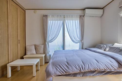 富士河口湖フルハウス的一间卧室，配有一张大床和一扇窗户。