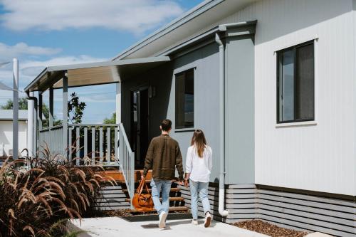 a man and a woman walking into a house at Mudgee Valley Park in Mudgee