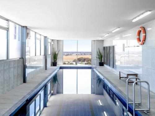 Una gran piscina en un edificio con ventanas. en Mantra Melbourne Airport, en Melbourne