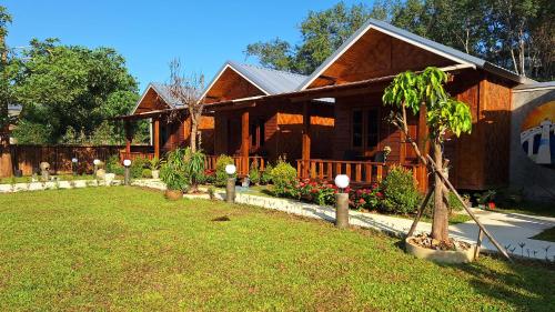 a house with a tree in front of a yard at Stay at Lanta Bungalow in Ko Lanta