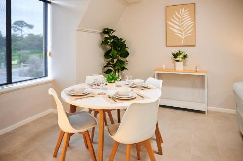 a white dining room with a table and chairs at Luxury Perth Apartment near Optus in Perth