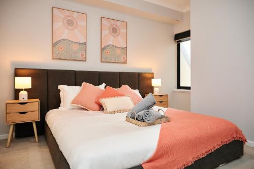 a bedroom with a large bed with orange sheets and pillows at Luxury Perth Apartment near Optus in Perth