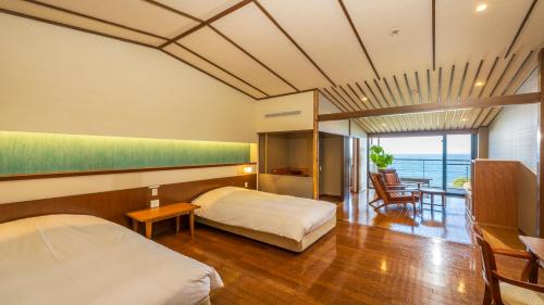 ein Schlafzimmer mit einem Bett und einem Tisch und Stühlen in der Unterkunft Hamachidorinoyu Kaisyu in Shirahama